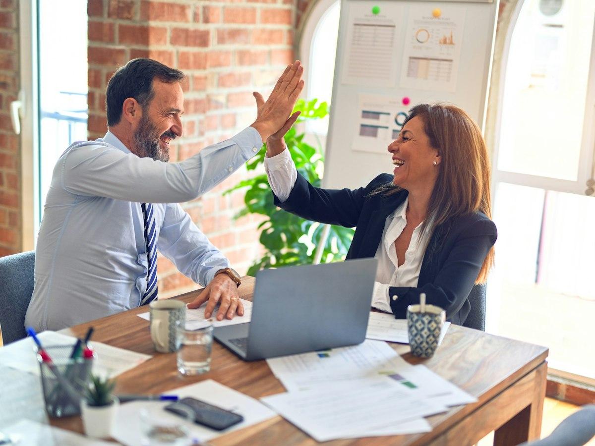 Two colleagues celebrating progress with a high five